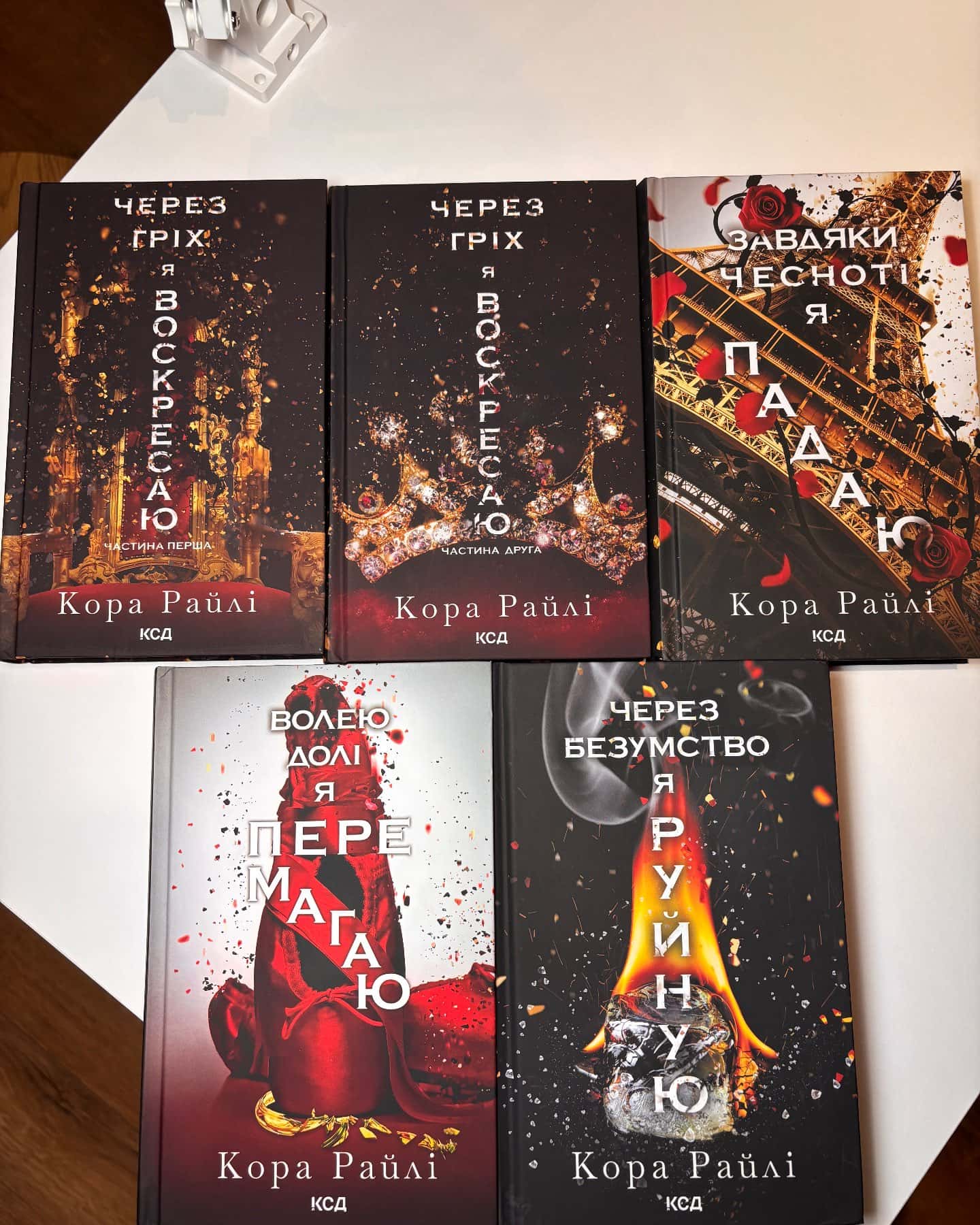 Через гріх я воскресаю. Частина 1, Через гріх я воскресаю. Частина 2, Завдяки чесноті я падаю. Гріхи батьків. Книга 3, Волею долі я перемагаю. Книга 4, Через безумство я руйную. Книга 5-Кора Рейлі